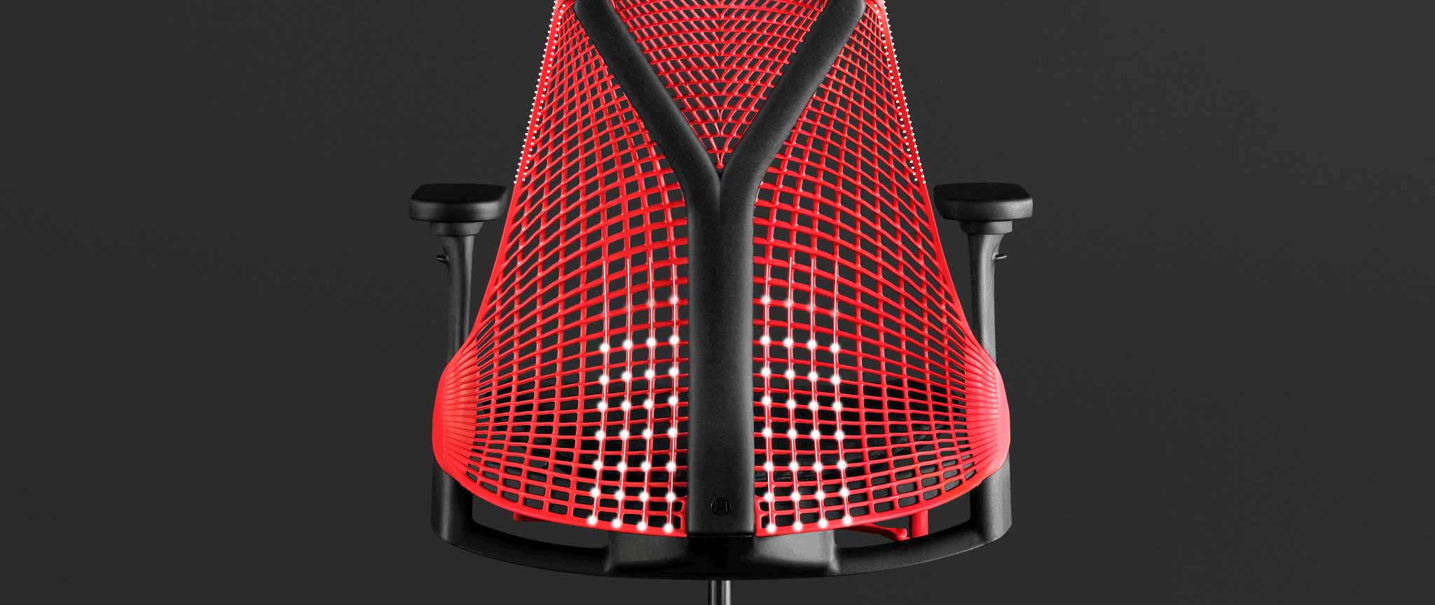 Achteraanzicht van een rood-zwarte Sayl-gamingstoel van Herman Miller, met witte afbeeldingen die de verende rugleuning benadrukken.