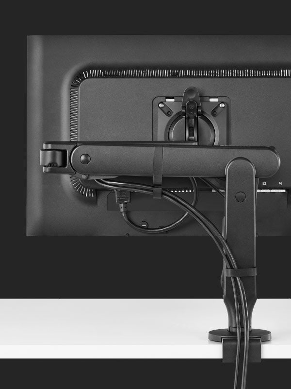 Achteraanzicht van een zwarte Ollin-gamingmonitorarm van Herman Miller, met de kabelbeheersfunctie.
