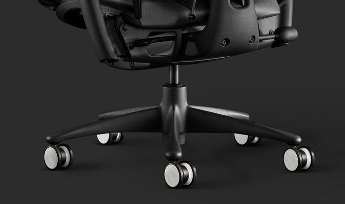 Close-up van een zwarte Embody-gamingstoel van Herman Miller, waarop de zwart-witte wieltjes te zien zijn.