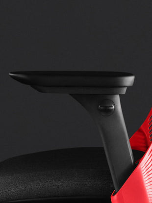 Close-up zijaanzicht van een rood-zwarte Sayl-gamingstoel van Herman Miller, met zichtbare verstelbare armleuningen.