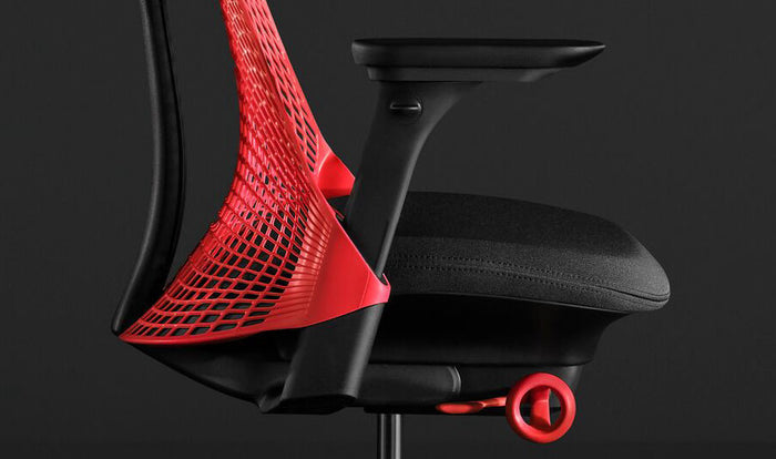 Close-up zijaanzicht van een rode en zwarte Sayl-gamingstoel van Herman Miller, met het voorgevormde zitkussen.