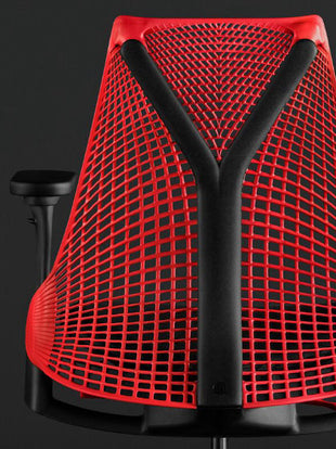 Achteraanzicht van een rode en zwarte Sayl-gamingstoel van Herman Miller, met de Y-vormige rugleuning.
