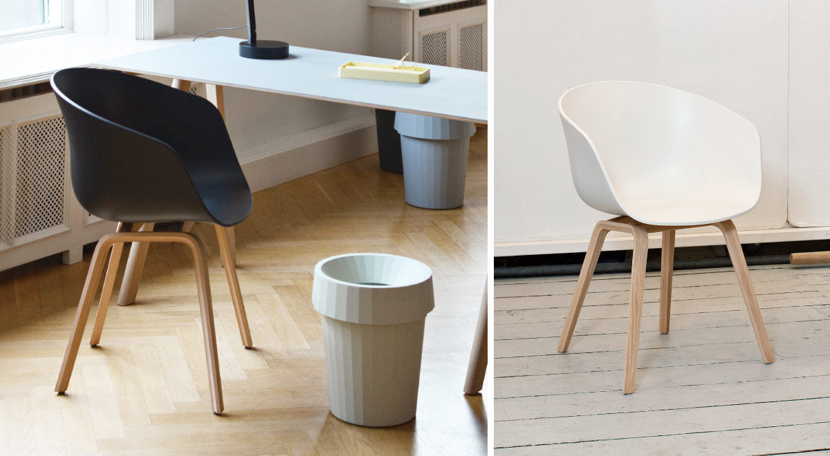 Een collage van twee afbeeldingen van twee AAC22-stoelen, één zwart en één wit. De foto is genomen in een binnenruimte met houten vloeren en witte muren.