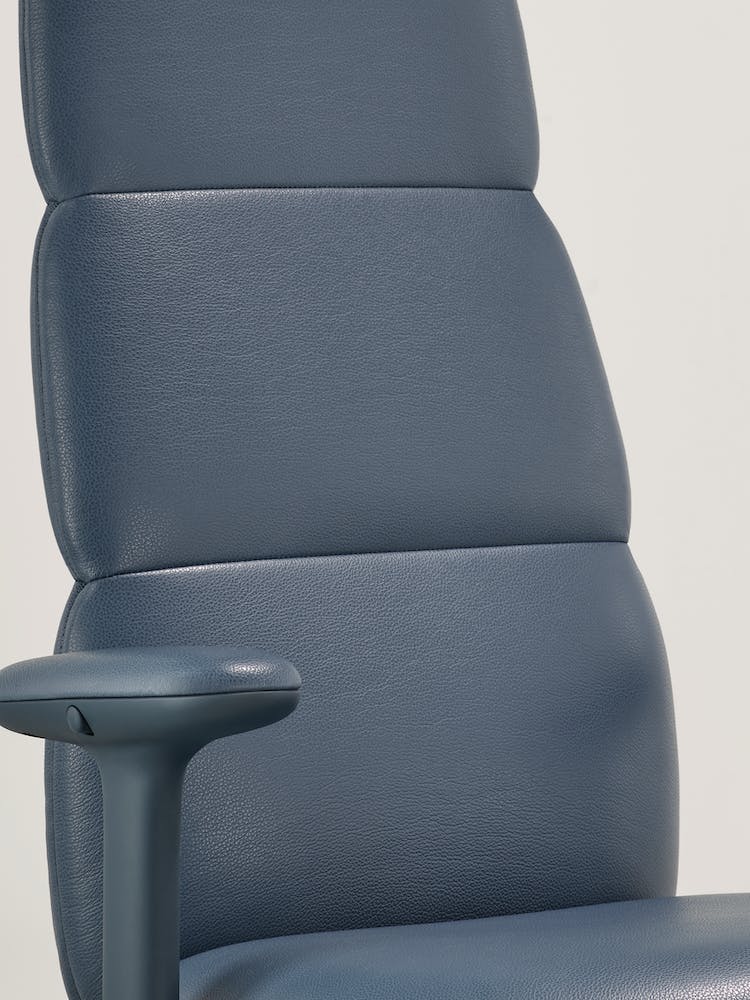 Close-up van een blauwe lederen Asari-bureaustoel van Herman Miller, met de geïntegreerde, interne Posturefit-technologie.
