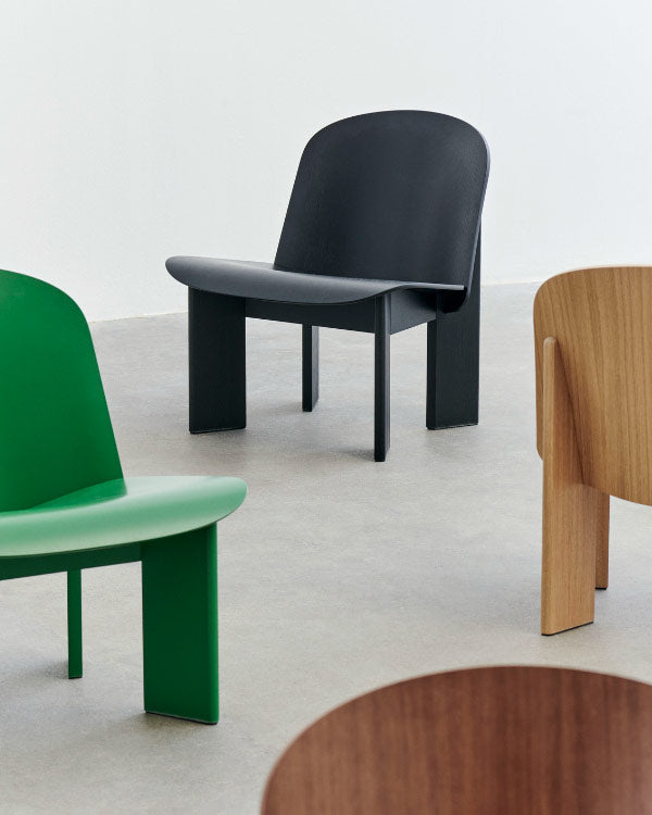 Groepsfoto van vier Chisel-fauteuils van HAY, waarop de verschillende kleuropties te zien zijn. Geplaatst in een binnenomgeving met betonnen vloeren en witte muren.