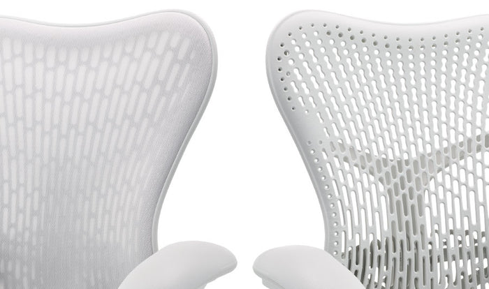 Twee witte Mirra 2-bureaustoelen van Herman Miller, naast elkaar geplaatst. Hier zijn de twee rugleuningopties te zien, één met een extra laag stof en één zonder.