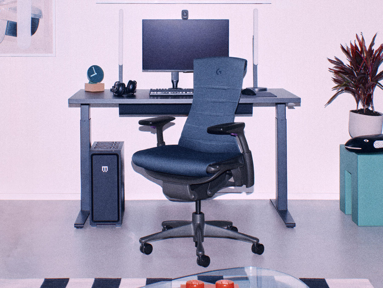 Zwarte Herman Miller Embody-gamingstoel met zwart Nevi-gamingbureau met zit-sta-functie en gamingopstelling met twee monitoren