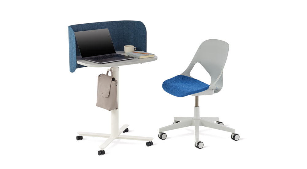 Een witte Passport-werktafel van Herman Miller met een blauw Passport-bureauscherm. Geplaatst naast een grijze en blauwe Zeph-bureaustoel.