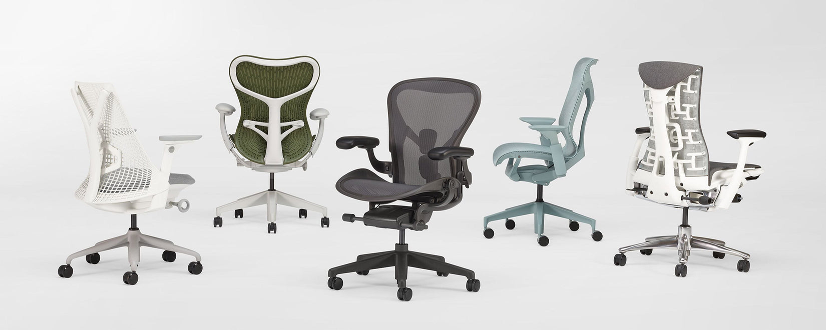 Een opstelling van 5 ergonomische bureaustoelen van Herman Miller in een witte studio. Met de Sayl, Mirra 2, Aeron, Cosm en Embody.