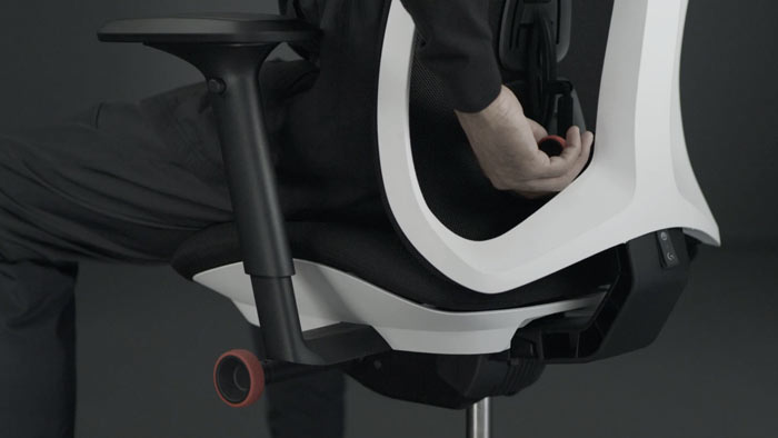 Een video van een persoon die in een wit-zwarte Vantum-gamingstoel van Herman Miller zit en achter de stoel reikt om de rugleuning te verstellen.