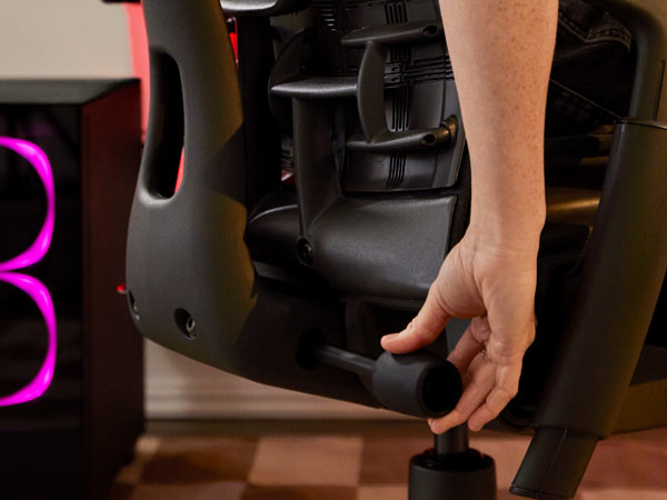 Close-up van Dr. Lindsey Migliore die de rugleuning van de Embody-gamingstoel verstelt