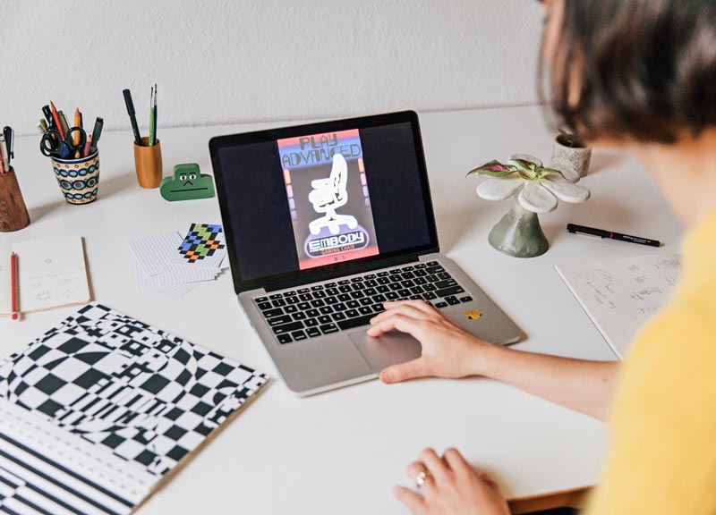 Close-up van de definitieve versie van de Embody gamingstoelposter op de laptop van Molly Rose Dyson