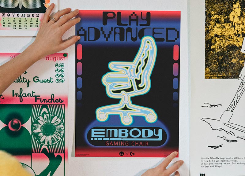 Foto van de definitieve poster voor de Embody gamingstoel, tegen de muur gehouden door Molly Rose Dyson