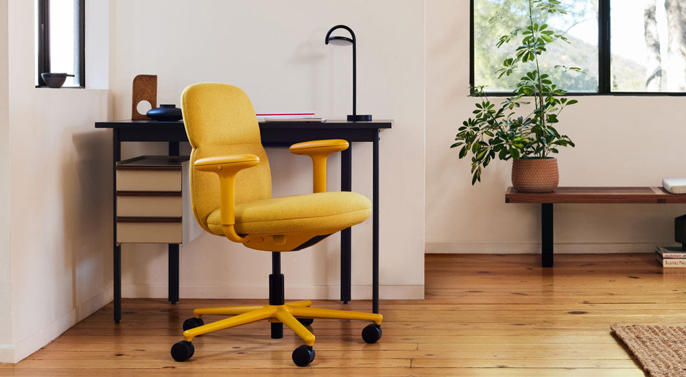 Een gele Asari-bureaustoel van Herman Miller, bekleed met Clarion Luce-stof van Maharam, met een Mode-bureau en Marselis-lamp.