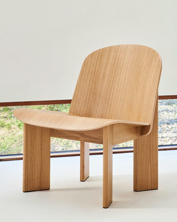 Vooraanzicht van een eikenhouten Chisel-fauteuil van HAY, geplaatst in een minimalistisch ingerichte woonruimte.