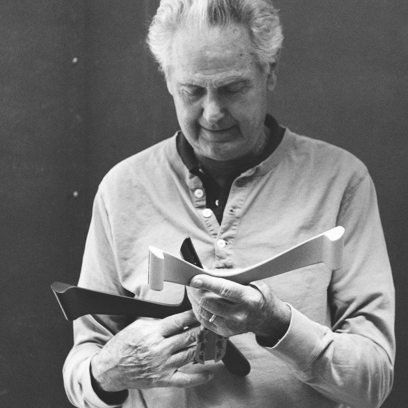 Zwart-witfoto van Don Chadwick met stoelonderdelen in zijn handen.