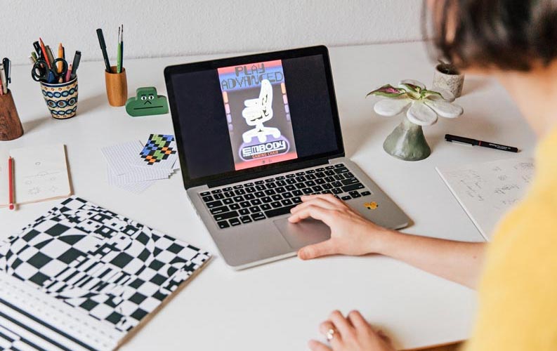 Ontwerpster Molly Rose Dyson werkt op een laptop aan een poster voor Herman Miller Embody.