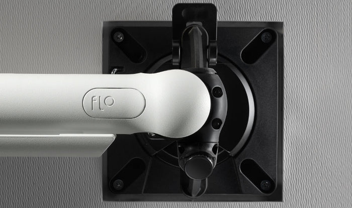 Vooraanzicht van een witte Flo-monitorarm van CBS, waarop de optionele staande of liggende stand te zien is.