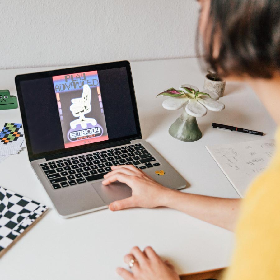 Ontwerpster Molly Rose Dyson werkt op een laptop aan een poster voor Herman Miller Embody