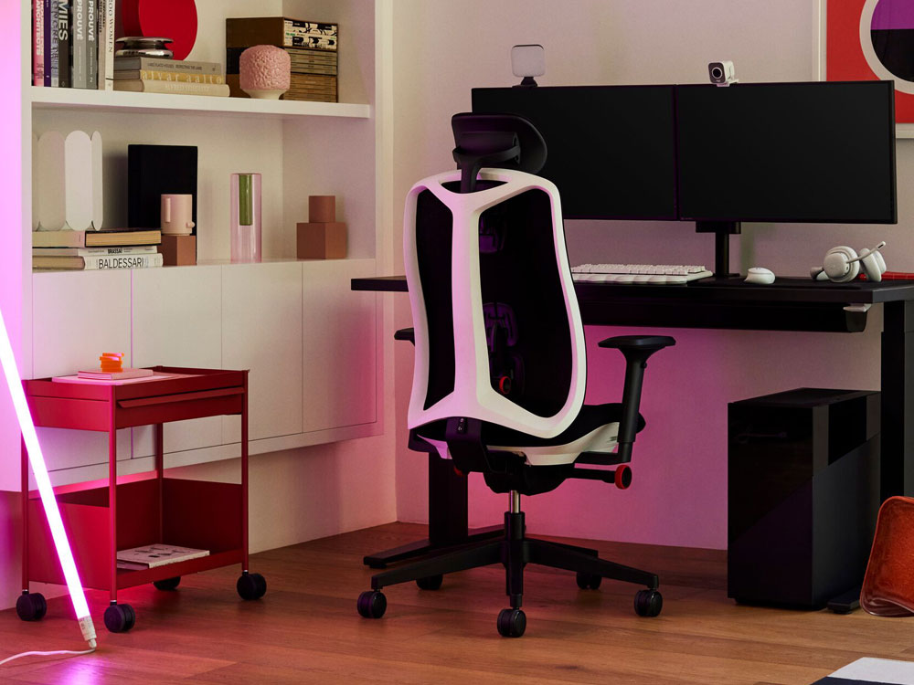Een Logitech x Herman Miller Vantum gaming stoel in wit als onderdeel van een gaming setup. Met Nevi bureau, Ollin monitor arm, OE1 trolley en een HAY neon LED buis.