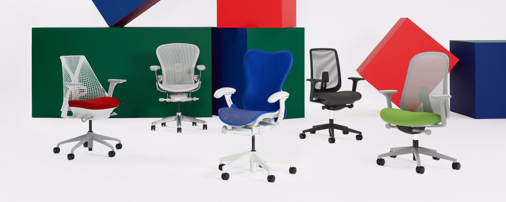 Een reeks Herman Miller-bureaustoelen in een studio-omgeving, waaronder Sayl, Aeron, Mirra 2, Verus en Lino in verschillende kleuren.