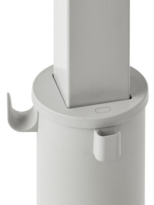 Close-up van een grijs OE1-sta-bureau van Herman Miller, met de tassenhaak en kabelhouder.