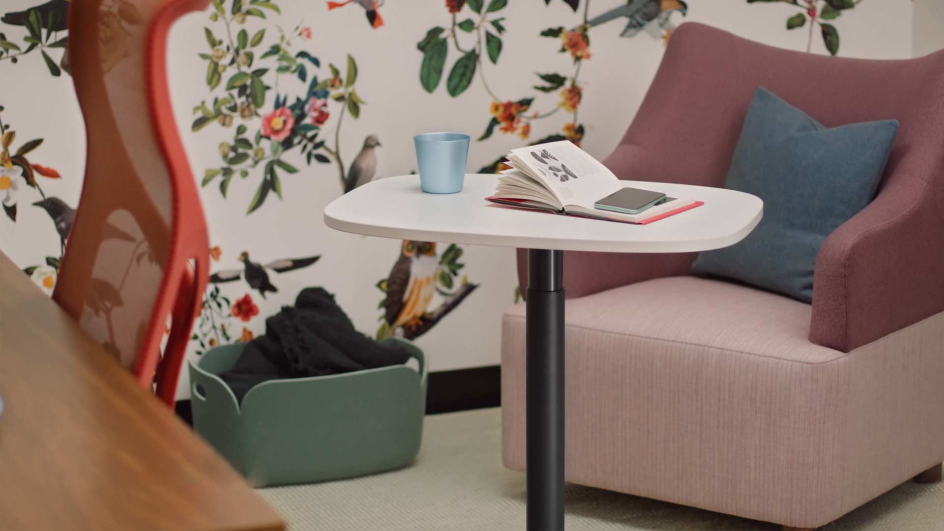 Een video van een vrouw die in een gele Wilkes-fauteuil zit en een Passport-tafel van Herman Miller gebruikt. De video laat vervolgens zien hoe de Passport-tafel op verschillende locaties wordt gebruikt, zowel op kantoor als thuis.