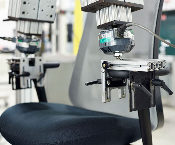 Foto van de dubbele armtest die het gewicht, de druk en de slijtage nabootst die alle stoelen van Herman Miller ondergaan.
