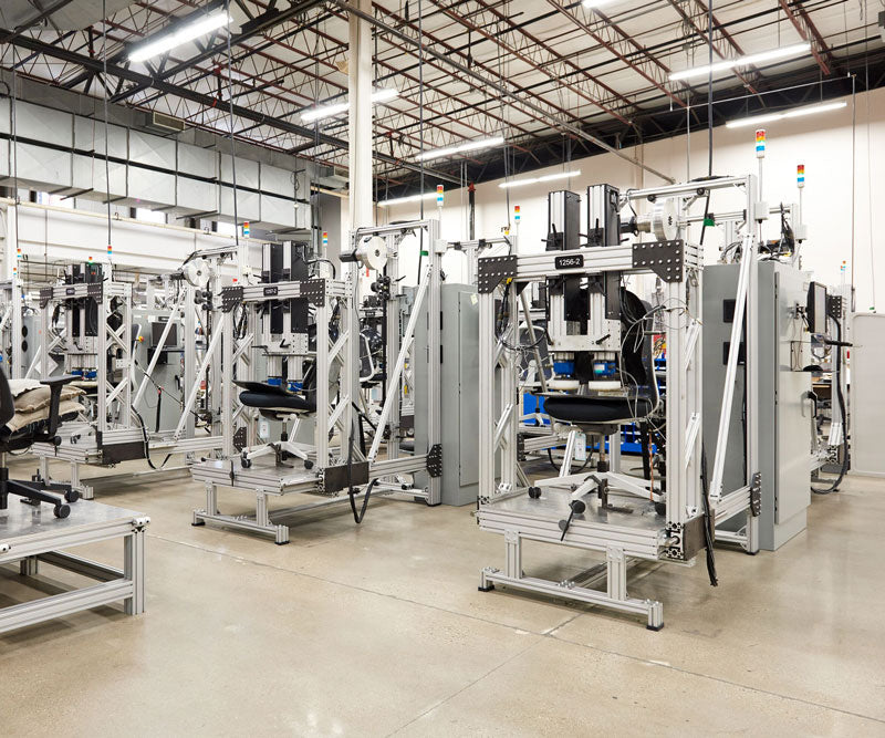 Foto van enkele machines die worden gebruikt om alle Herman Miller-bureaustoelen te testen.