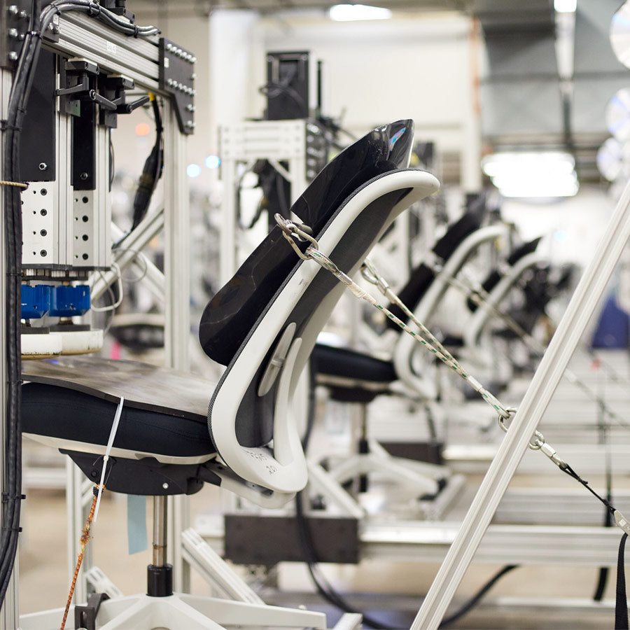 Foto van een Herman Miller-stoel die wordt getest op duurzaamheid in het testlaboratorium van Herman Miller