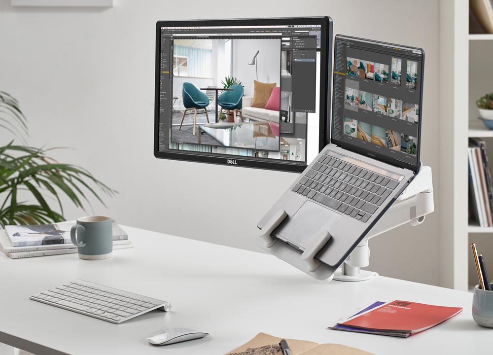 Een witte Lima-monitorarm voor twee monitoren van CBS met een witte laptopbevestiging, waarop het computerscherm en de laptopbevestiging te zien zijn.