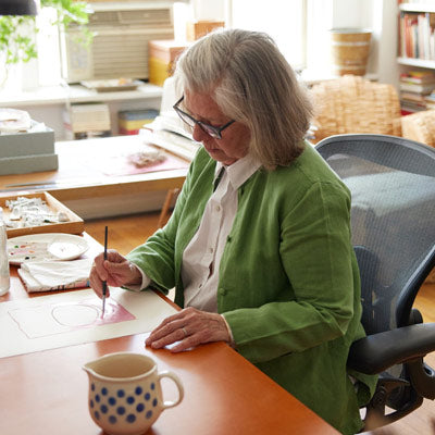 Illustrator, schilder en auteur zittend aan het schilderen in een Herman Miller Aeron-bureaustoel in grafiet