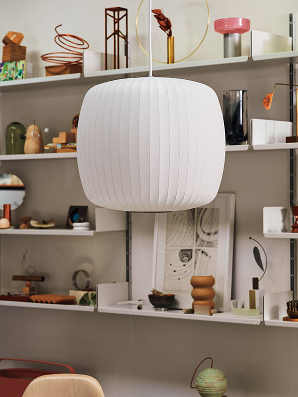 Close-up van Roll Nelson Bubble-plafondlamp hangend voor planken vol iconische ornamenten