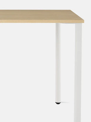 Close-up vooraanzicht van een wit en essenhouten OE1-bureau van Herman Miller, met het duurzame en gemakkelijk te reinigen tafelblad.