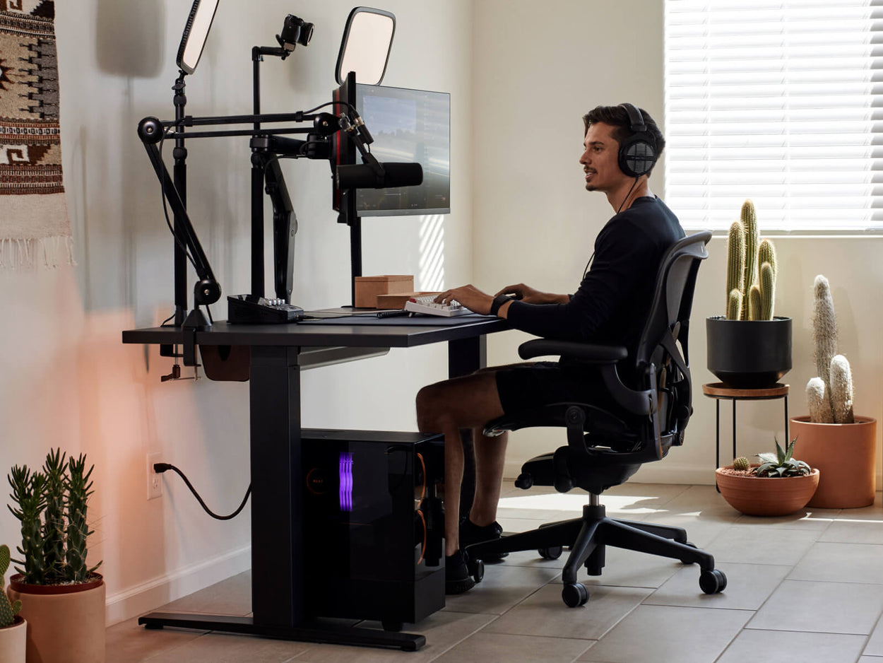 Gamer Xaryu speelt een game op zijn Herman Miller-opstelling in een Aeron-gamingstoel met een Nevi-gamingtafel en Ollin-dubbele monitorarmen