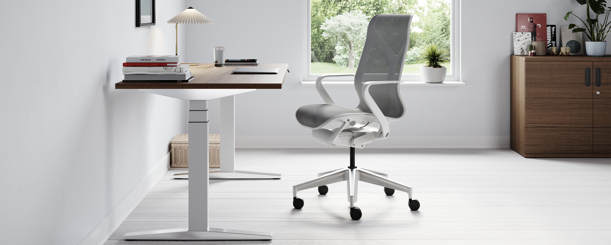 Grey and white Cosm chair next to a Ratio sit stand desk in a home office setting